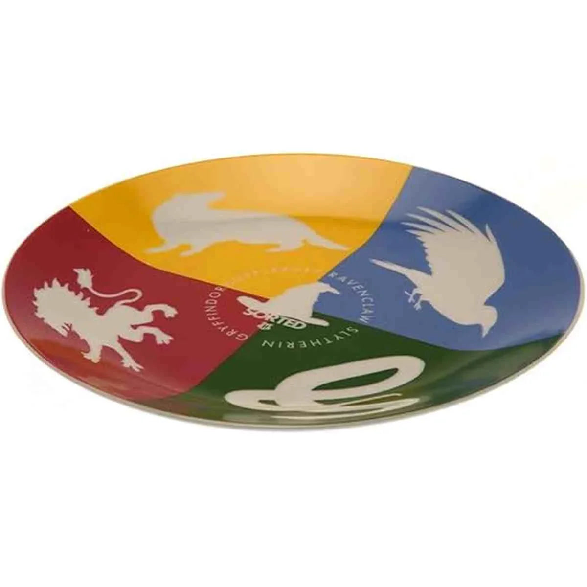 Assiette circulaire divisée en quatre sections colorées (jaune, rouge, bleu et vert) avec les symboles des maisons de Poudlard : lion pour Gryffondor, serpent pour Serpentard, aigle pour Serdaigle, et blason de la maison Poufsouffle.