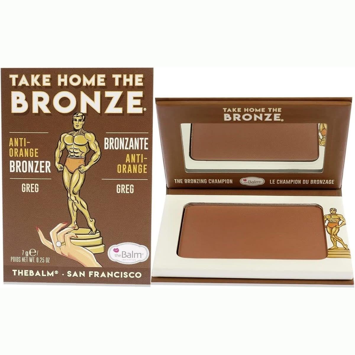 Boîte de bronzant "Take Home The Bronze" de theBalm, présentant un embossage d'un homme musclé en costume, avec le texte "Take Home The Bronze" et les mentions "Anti-Orange" et "Greg", en packaging marron et beige
