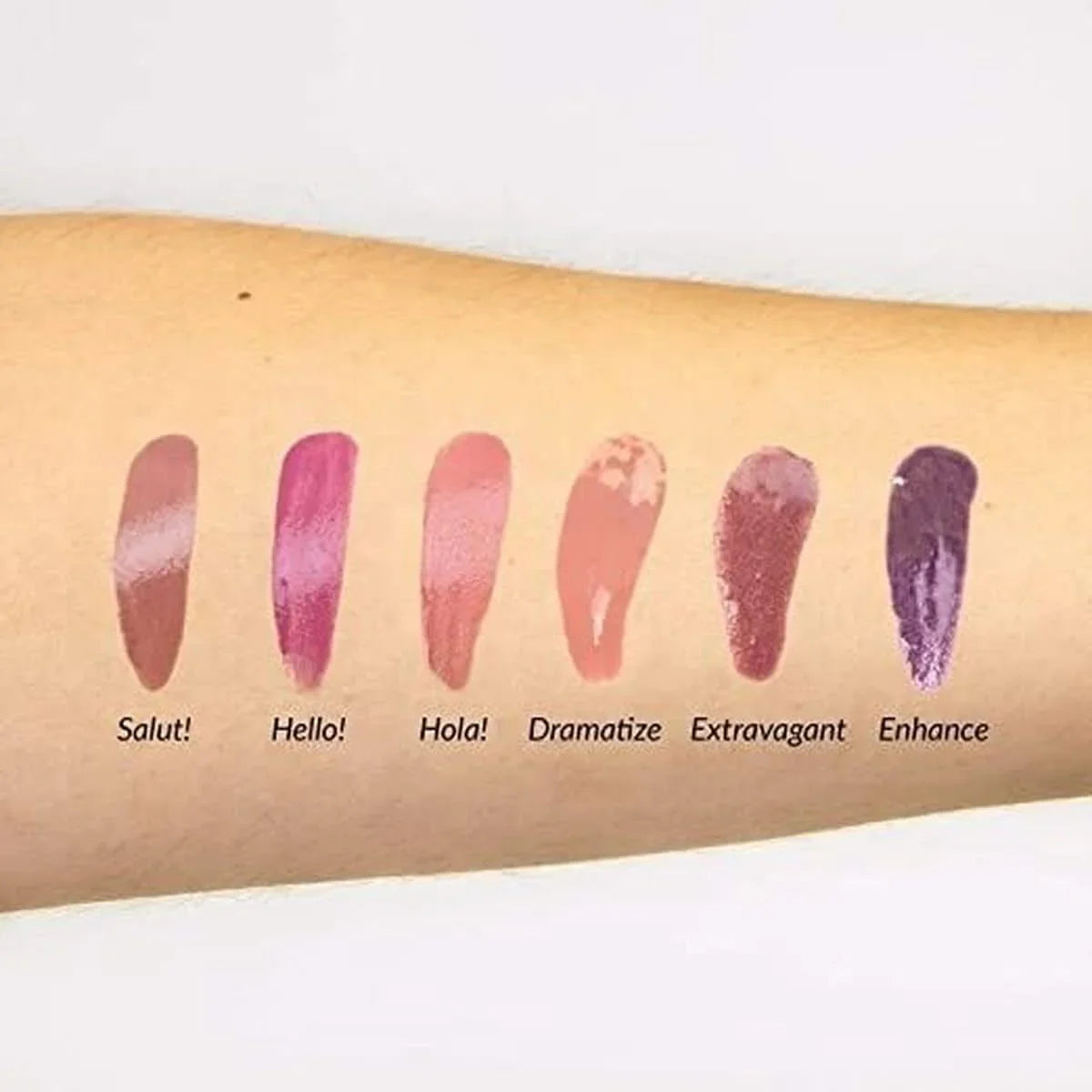 Swatches de six teintes de gloss à lèvres sur un avant-bras, avec noms : Salut!, Hello!, Hola!, Dramatize, Extravagant, Enhance.