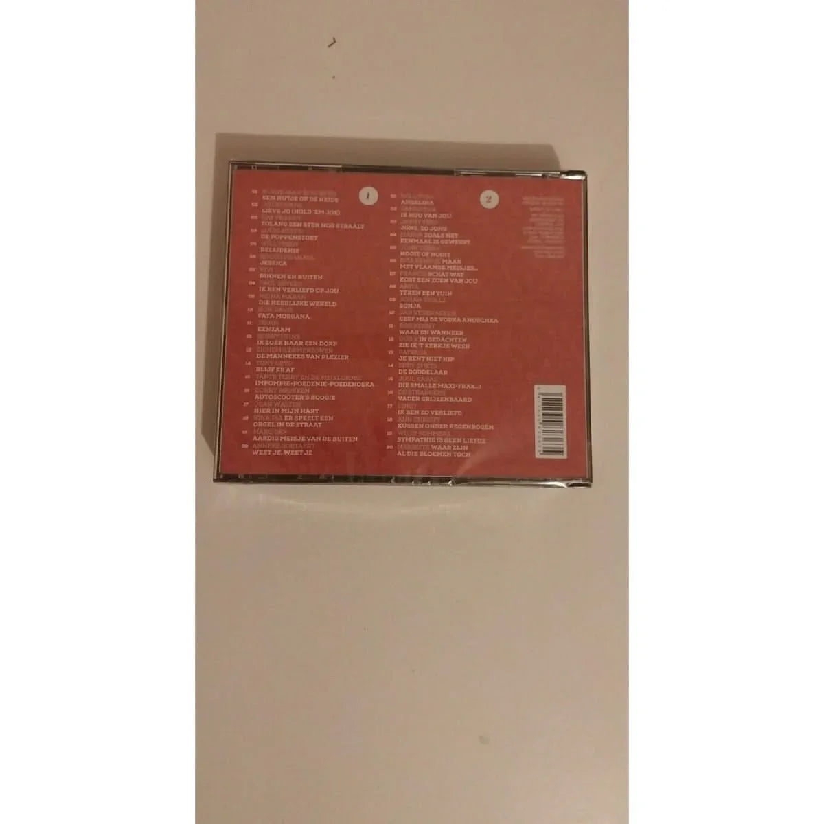 Liste des titres et artistes présents dans le coffret de 2 CD « Liedjes Van Vroeger Volume 4 », avec une illustration d’un fond coloré 