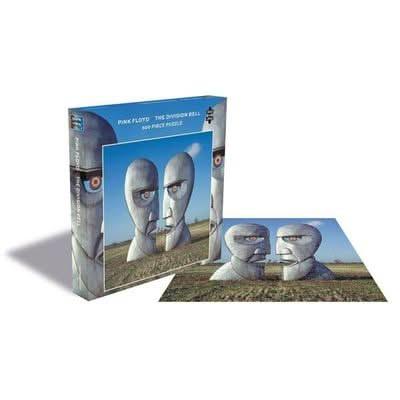 Photo du puzzle "Pink Floyd - The Division Bell" de 500 pièces, représentant deux grandes sculptures en pierre se faisant face dans un paysage en plein air, avec la boîte du puzzle illustrée à côté